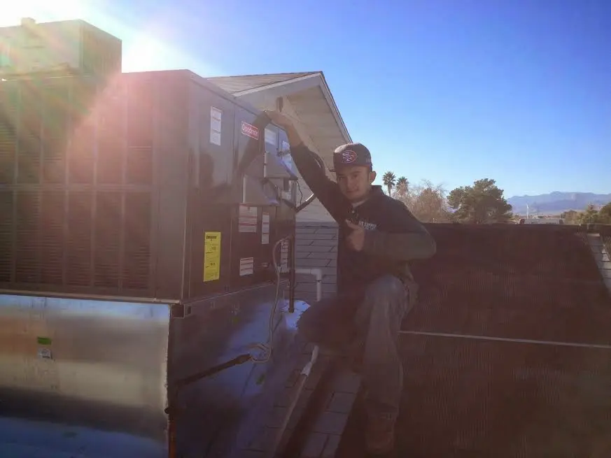 HVAC technician performing AC Tune-Up on a rooftop unit in Whitpain